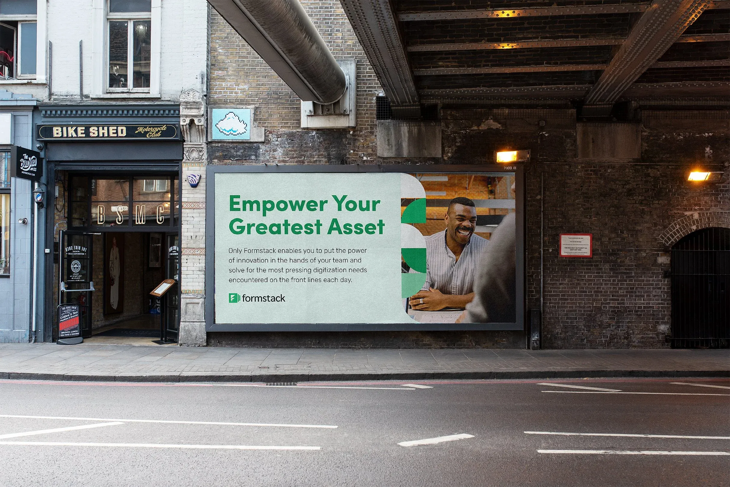 Formstack billboard under a city railway bridge: “Empower your greatest asset”